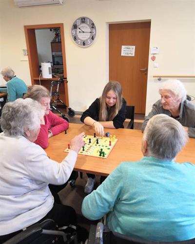 Eine Gruppe von Menschen, die um einen Tisch sitzen und ein Brettspiel spielen